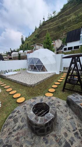 a fire pit in a yard with a tent at Mahkota Sangkuriang Bandung in Bandung