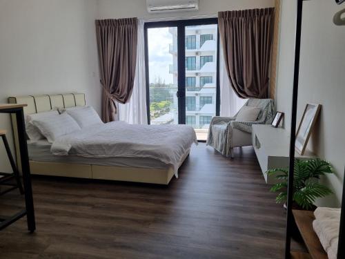 a bedroom with a bed and a chair and a window at Happy Homestay in Kuching