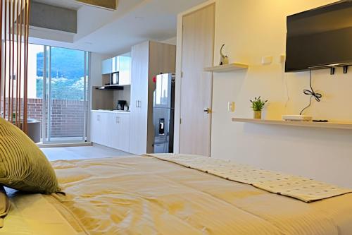 a bedroom with a large bed with a television on the wall at Apartamento ideal: moderno en Centro Internacional in Bogotá