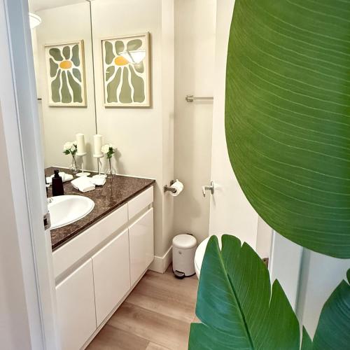 a bathroom with a sink and a mirror at Stunning Skyline Views in a Cozy and Stylish Abode in Vancouver