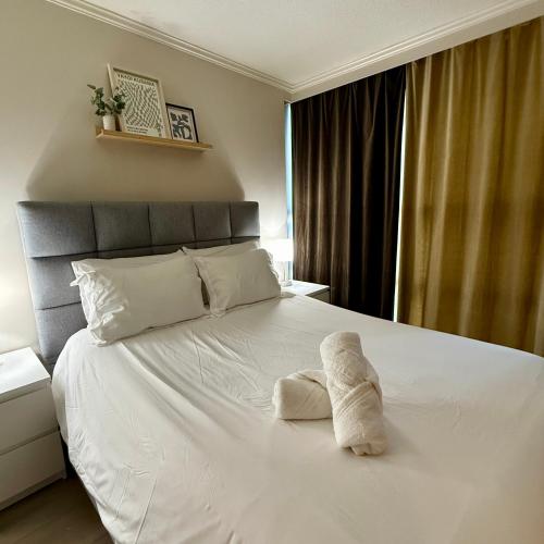 a bedroom with a bed with a towel on it at Stunning Skyline Views in a Cozy and Stylish Abode in Vancouver