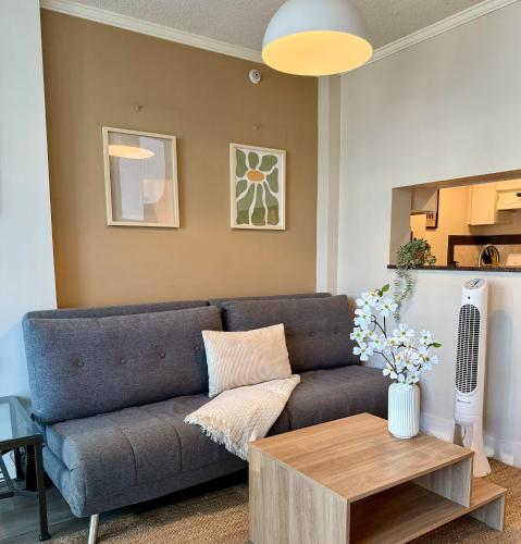 a living room with a couch and a table at Stunning Skyline Views in a Cozy and Stylish Abode in Vancouver