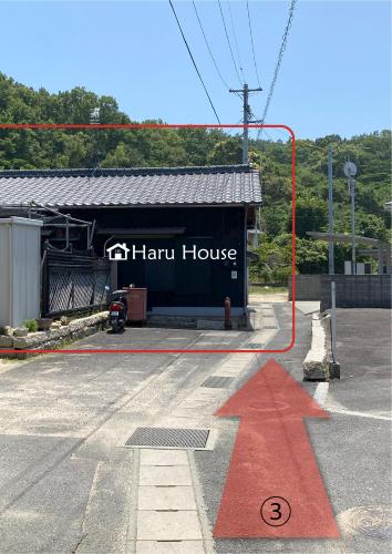 a red arrow in front of a hart house at Naoshima Haru House in Naoshima
