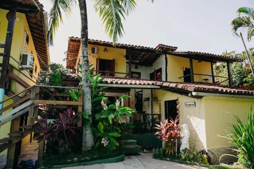 una casa con palmeras delante en Pousada Arraial Lua Crescente, en Arraial d'Ajuda