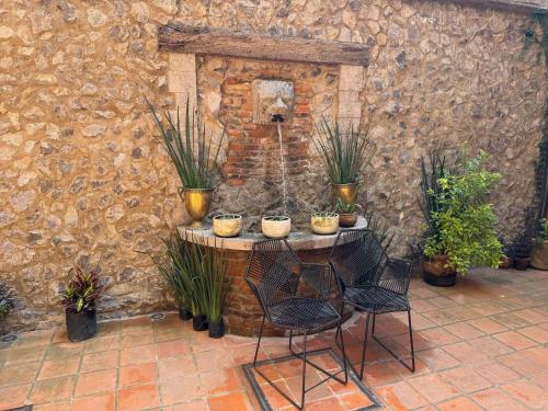 a table with potted plants on it next to a stone wall at Dolce Angelo en ValQuirico in Santeagueda
