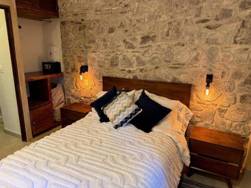 Bett in einem Zimmer mit einer Steinmauer in der Unterkunft Lucca 81 en ValQuirico in Santeagueda