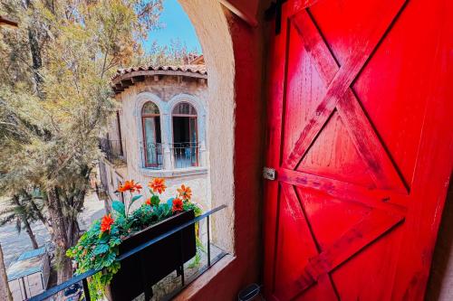an open red door with a window and flowers on a balcony at Loft Iduri en ValQuirico in Santeagueda