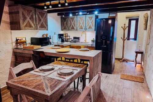 a kitchen with a wooden table and a refrigerator at Loft Iduri en ValQuirico in Santeagueda