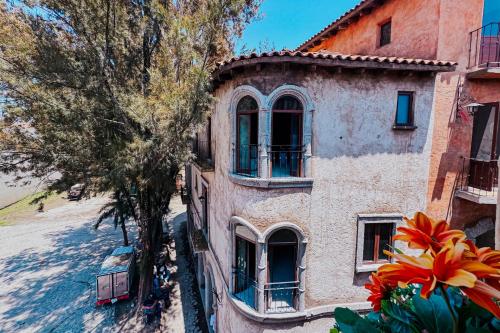 an old building with windows and a tree at Loft Iduri en ValQuirico in Santeagueda
