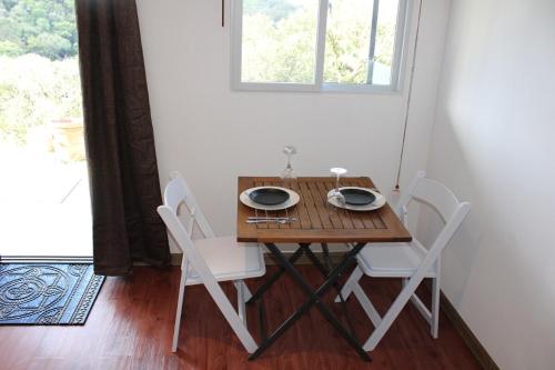 un tavolo in legno e due sedie in una stanza con finestra di mountain cabin with private waterfall and river a Monteverde Costa Rica