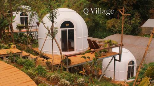 a small white dome house in a garden at Q Village Homestay Đà Lạt in Da Lat