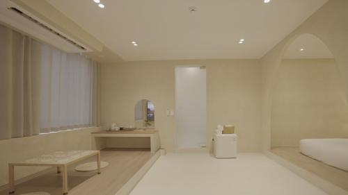 a bedroom with a bed and a table and a sink at Island Stay in Jeju