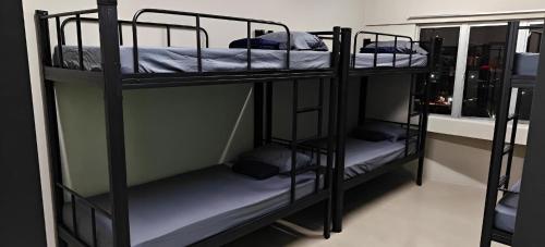 a room with three bunk beds in a room at Jeea Hostel in Kuala Lumpur