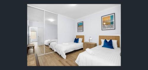 a bedroom with two beds with blue pillows at East Perth Apartment Suites with Parking in Perth