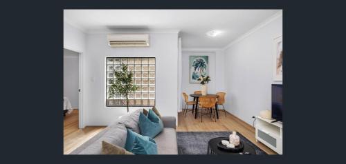 a living room with a couch and a table at East Perth Apartment Suites with Parking in Perth