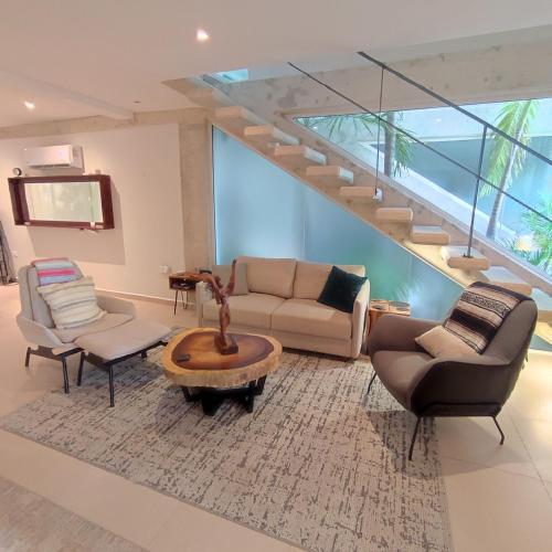 a living room with a couch and chairs and a staircase at Casa Joya - Luxury 3 Bed 4 Bath Home with View - Puntarena in Puerto Morelos