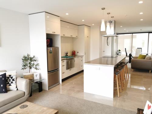 a kitchen and living room with a couch and a table at Mountain View Townhouse, New Plymouth in New Plymouth