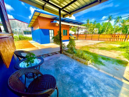 a patio with two chairs and a table and a house at Lamai Home 3 in Ko Yao Noi