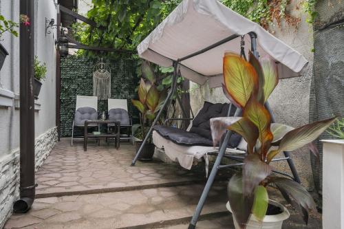 a patio with an umbrella and a chair and a plant at White house parc Carol in Bucharest
