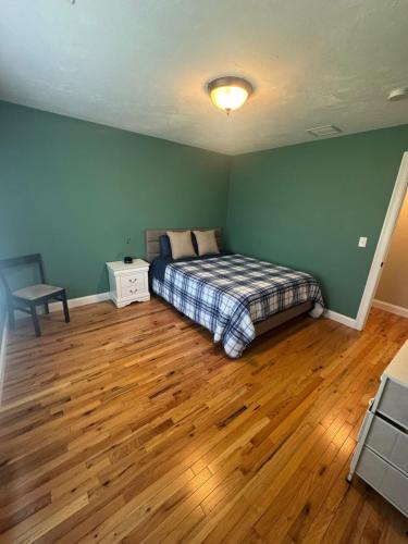 a bedroom with a bed and a wooden floor at Elegant 3BR Home in Worcester in Worcester
