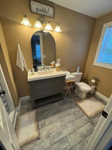 a bathroom with a sink and a toilet and a mirror at Elegant 3BR Home in Worcester in Worcester