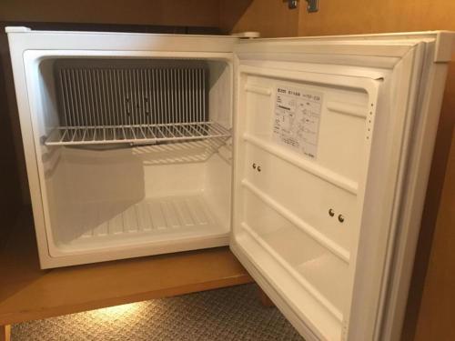 an empty refrigerator with its door open in a kitchen at Diamond Hotel Tokyo in Tokyo