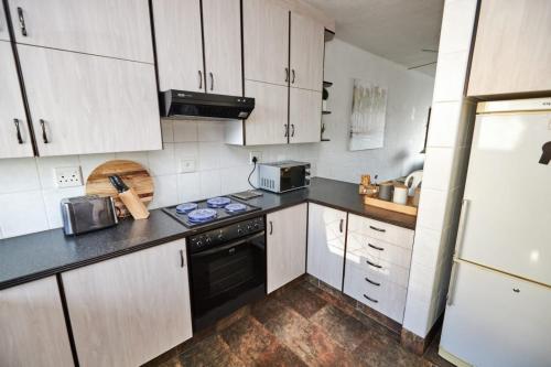 a kitchen with white cabinets and a black stove top oven at 65 @ Zeezicht in Kingsburgh