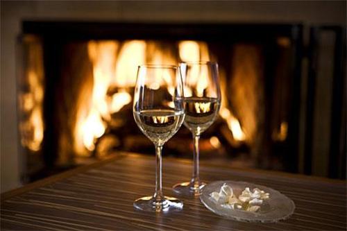 two wine glasses sitting on a table in front of a fireplace at Cupids Arrow Holiday home in Gatlinburg
