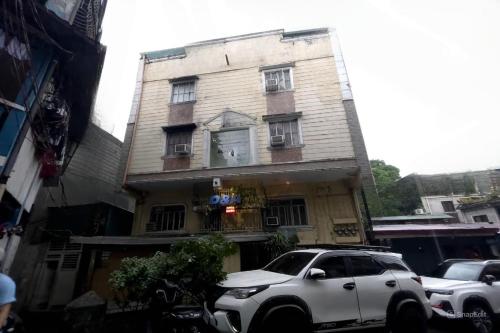 einem weißen SUV vor einem Gebäude in der Unterkunft D and A Transient Inn Taguig in Taguig