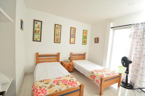 two beds in a room with a window at CASABLANCA, la calidez de tu hogar en Villeta in Villeta