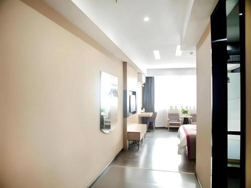 une chambre d'hôtel avec un lit et une table dans l'établissement Thank Inn Hotel Jiangsu Wuxi Jiangyin District Ligang Street Xinggang Road, à Jiaoxi