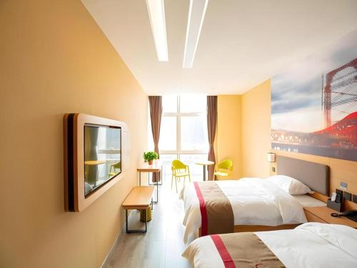 a hotel room with two beds and a tv at Thank Inn Hotel Tianjing Jinnan University in Tianjin