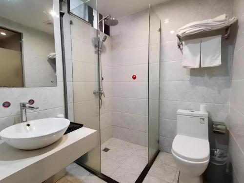 a bathroom with a sink and a toilet and a shower at Jun Hotel Hubei Wuhan Jianghan District Jianghan Road Walking Street in Wuhan