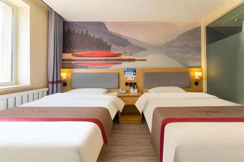 a room with three beds and a painting on the wall at Thank Inn Plus Hotel Xinjiang Urumqi Tianshan District Bingtuan Erzhong in Ürümqi