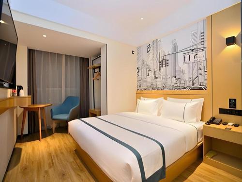 a hotel room with a bed and a blue chair at City Comfort Inn Kunming High Speed Railway South Station Yongxin Harvard in Kunming