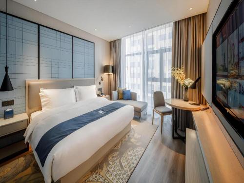 a bedroom with a large bed and a large window at Echarm Hotel Nanning Dongge Macun Metro Station in Nanning