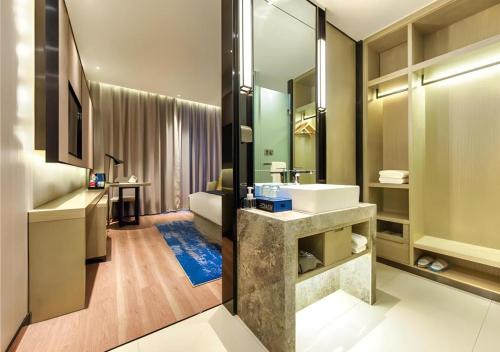 a bathroom with a sink and a large mirror at Echarm Hotel Qianxi High Speed Railway Station in Qianxi