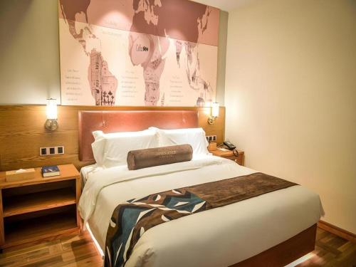 a bedroom with a large bed with a large poster on the wall at James Joyce Coffetel Luoyang Longmen High-speed Railway Station Baolong Plaza in Luoyang