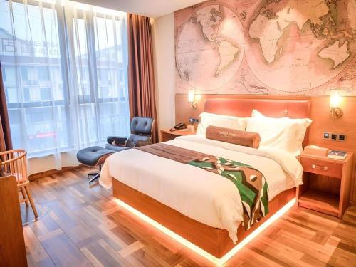 a hotel room with a large bed and a map on the wall at James Joyce Coffetel Luoyang Longmen High-speed Railway Station Baolong Plaza in Luoyang