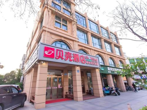 a building with a sign on the side of it at Shell Hotel Yangzhou Yangzijiang Bei Road Slender West Lake Scenic Area in Yangzhou