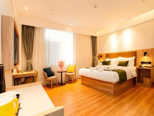 GuoyangにあるGreenTree Inn Express Bozhou Woyang County Huaizhong Avenue Zhonghai Internationalのベッドと大きな窓があるホテルの部屋