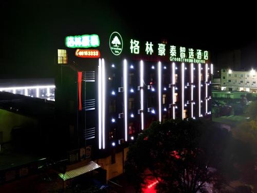 a lit up building with chinese signs on it at night at GreenTree Inn Linhai Jiangnan Avenue Express in Linhai