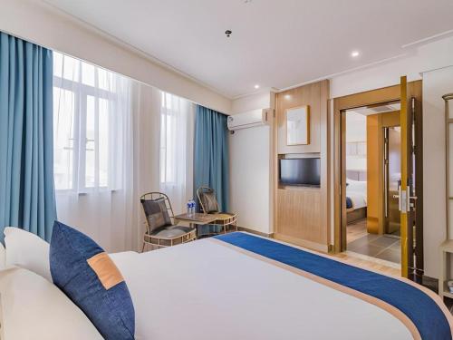 a hotel room with a bed and a television at Borrman Hotel Huizhou West Lake Shuidong Street in Huizhou