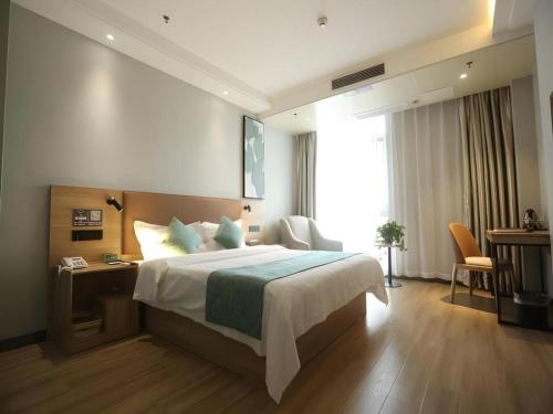 a hotel room with a large bed and a desk at GreenTree Inn Anqing Yingbin Dong Road High-Speed Railway Station in Anqing