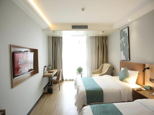 a hotel room with two beds and a television at GreenTree Inn Anqing Yingbin Dong Road High-Speed Railway Station in Anqing