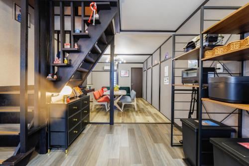a room with a staircase and a living room at 新大阪旅庵 民泊彩庵 in Osaka