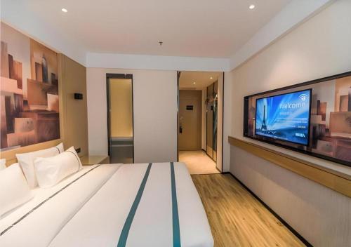 a bedroom with a large bed and a flat screen tv at City Comfort Inn Kunshan Development Zone Penglang Xinxing Middle Road in Suzhou