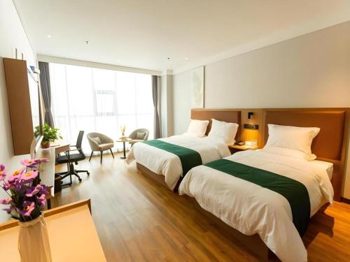a hotel room with two beds and a desk at GreenTree Inn Express Datong High-Speed Railway Station Wanda Plaza Fangte in Datong
