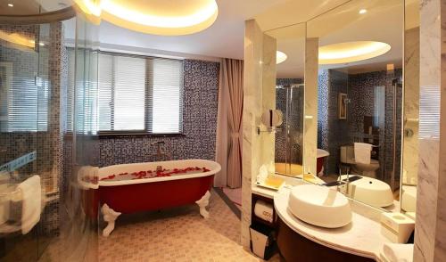 a bathroom with a red tub and a sink and a shower at Xingtai Yuehai Hotel in Haikou