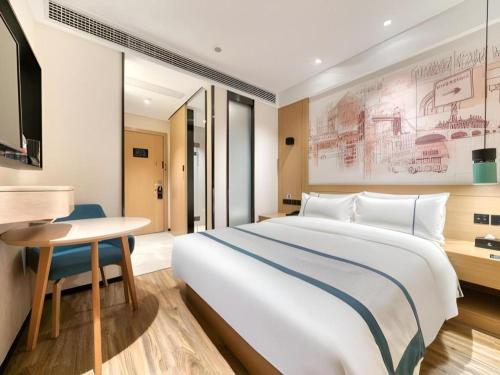 a hotel room with a large bed and a table at City Comfort Inn Dong'an Avenue County Government in Guzhuting